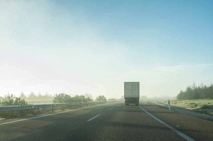 driving behind a truck under morning haze. bad weather driving concept